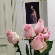 Photo d'un petit bouquet de roses devant un portrait de femme