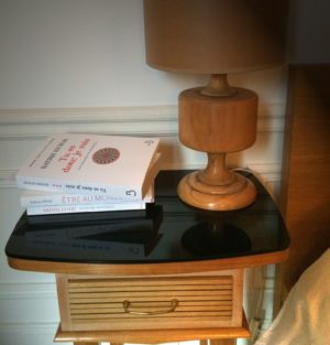Photo d'une table de chevet avec des livres et une lampe