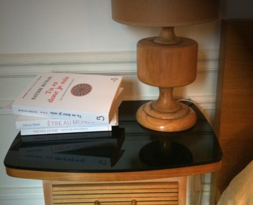 Photo d'une table de chevet avec des livres et une lampe