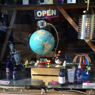 Photo d'un globe terrestre entouré de divers objets, posés sur une table, un signe "open" placé juste au-dessus