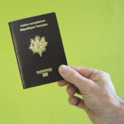 Image d'un passeport tenu à la main, sur fond vert
