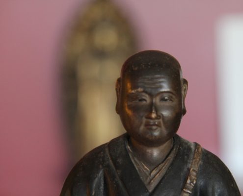 Image du buste d'une sculpture de bouddha, devant un arrière-plan flou