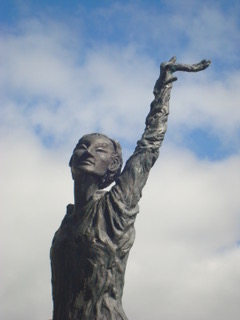 Photographie d'une statue de Barbara levant la mains au ciel