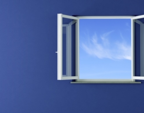 Image d'une fenêtre ouverte sur un ciel légèrement nuageux